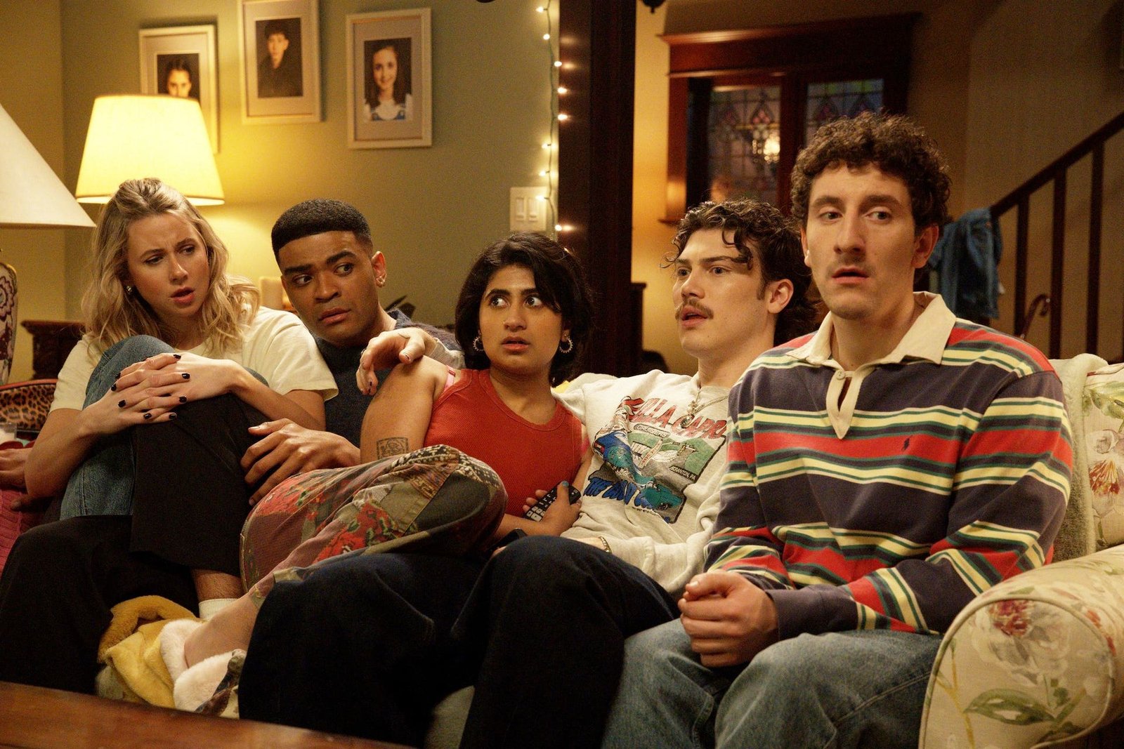 A group of two women and three men sitting on a couch