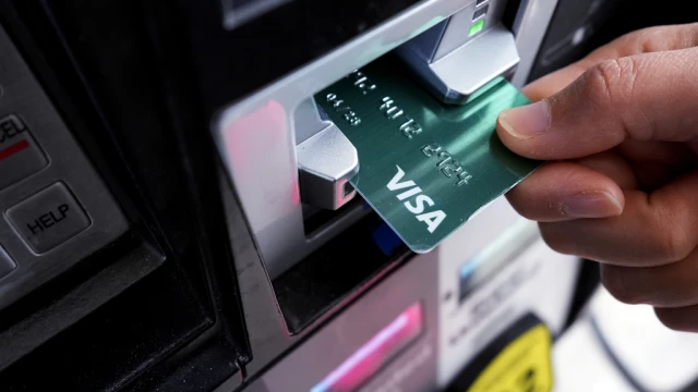 A customer uses a Visa credit card to pay for gasoline at a gas station.