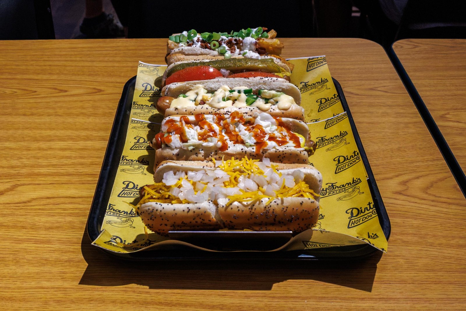 a lineup of hot dogs including a chili dog, chicago dog, potato dog, and more from dirty frank’s in columbus, ohio