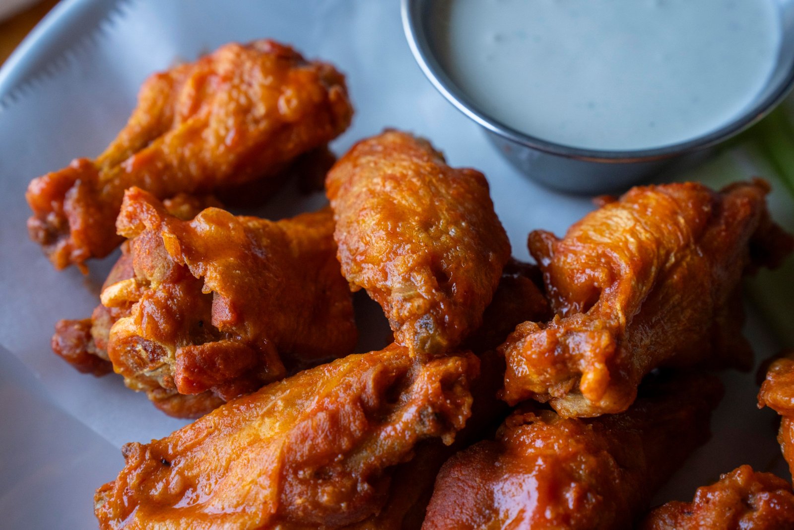 Chicken wings and a small container of creamy sauce.