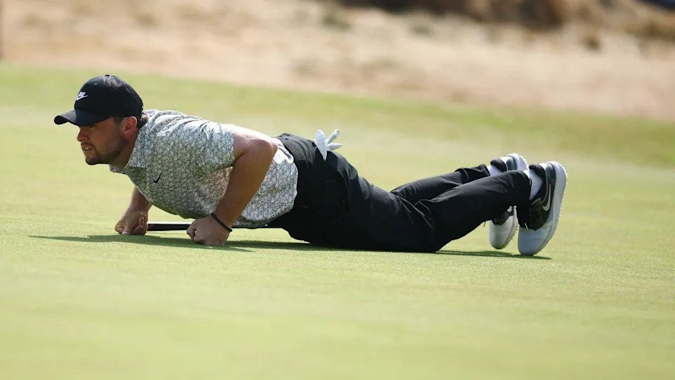 Alex Fitzpatrick gets on his hands and knees to read a putt during the Open Championship at Royal Birkdale
