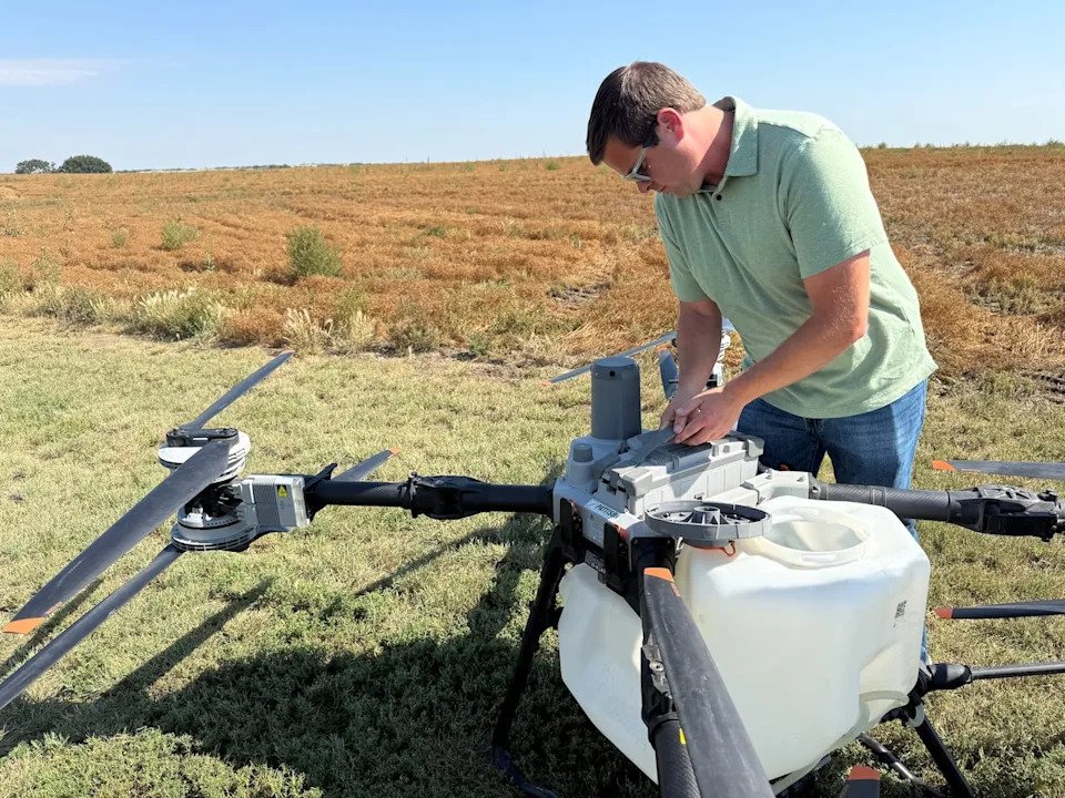 Dean Roberts places a battery inside the spray drone he's considering for his farm. Roberts has used drones in the past to locate rocks on his farm that can cause expensive damage to his other equipment, but a recent federal policy decision now allows him to use drones to apply specific pesticides on crops.
