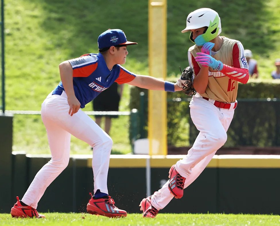 Third basemen Leo Feltner of Hamilton West Side (Great Lakes region) tags out runner Jace Ward of Henderson, Nevada, (Mountai
