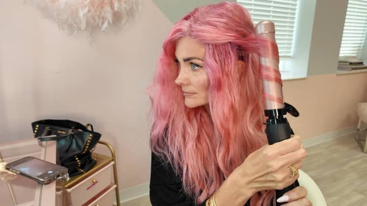 Beachwaver CEO Sarah Potempa uses the company's namesake product, a patented rotating curling iron.