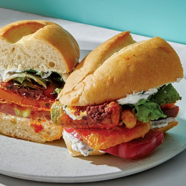 A butternut squash and zucchini torta cut in half on a plate.
