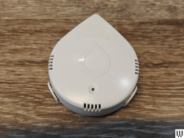 White water droplet shaped device with small slit openings on each side sitting on wooden surface. One of the best water...