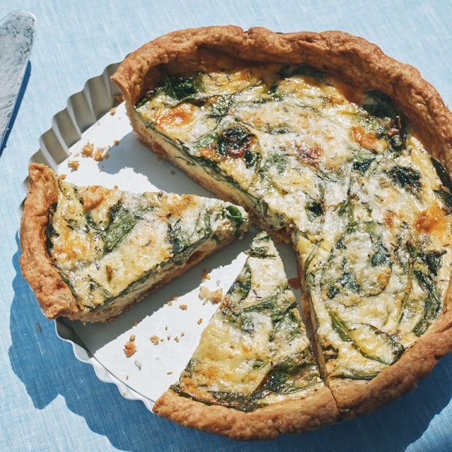 A sliced caramelized onion and spinach quiche.