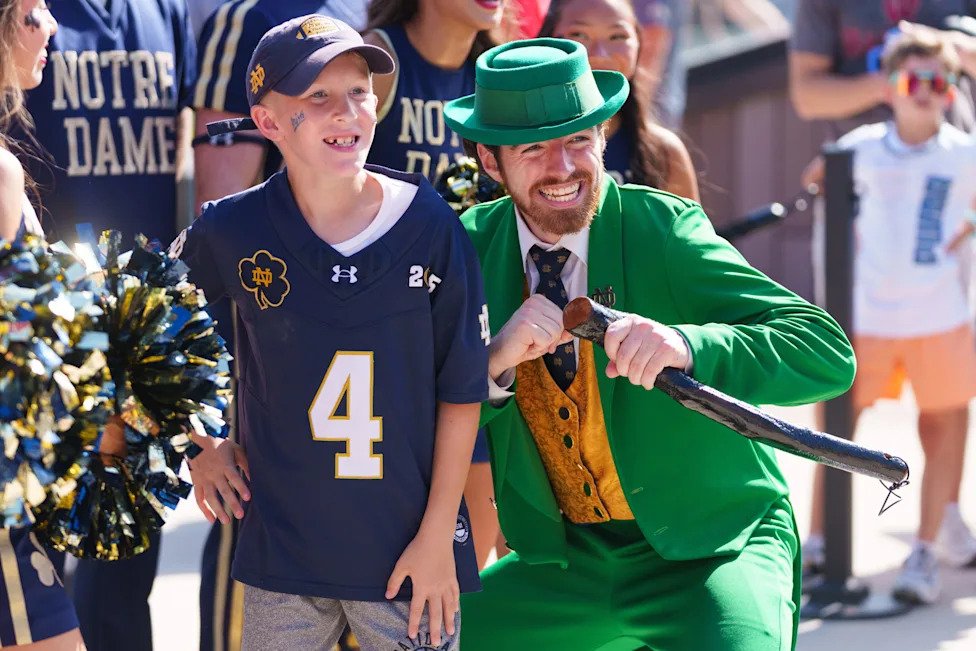Aidan Cassel, left, 10-years-old from Madison, WI, poses for a photo with the Notre Dame leprechaun before a NCAA football ga