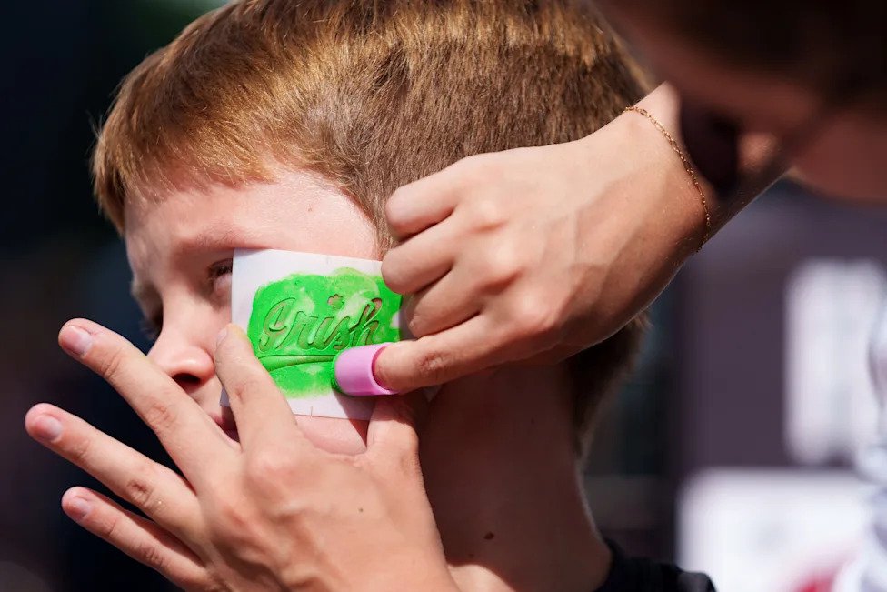 Ryan Schreiber, 11, from Chicago, gets Irish face painting done before a NCAA football game between Notre Dame and Wisconsin 