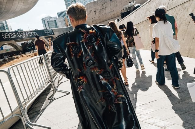 Image may contain Clothing Coat Adult Person Formal Wear Accessories Bag Handbag Teen Footwear Shoe and Jeans