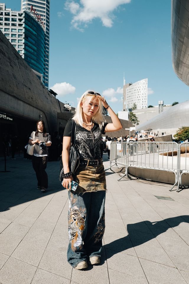 Image may contain Keiko Agena Clothing Pants Adult Person Accessories Bag Handbag Urban City Face and Head