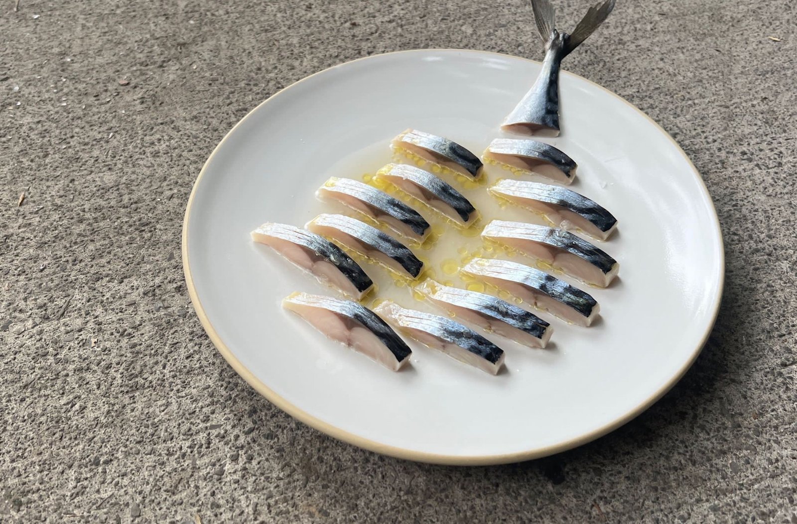 A piece of fish sliced into small portions and arranged geometrically.